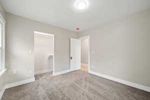 Unfurnished bedroom featuring carpet and baseboards