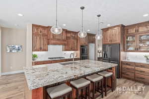 Large island with granite countertops, custom solid wood cabinetry and beautiful pendant lights.