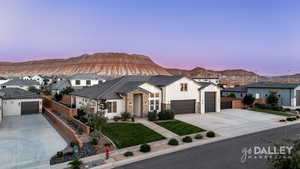 View of front of property featuring a mountain view, board and batten siding, driveway, and stone siding