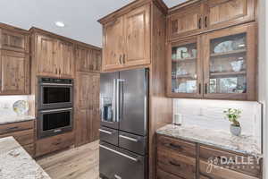 You can see the pantry door is closed and hidden in this photo next to the double ovens. Beautiful cabinetry really sets this home apart.