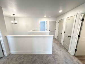 Hall with light carpet and recessed lighting