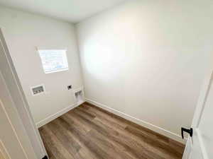 Laundry area featuring wood finished floors, washer hookup, and hookup for an electric dryer