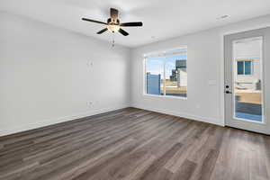 Unfurnished room featuring dark wood-style floors and a ceiling fan