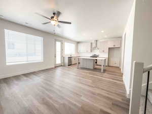 Kitchen with open floor plan, light countertops, light wood-style floors, a kitchen island, and a breakfast bar area