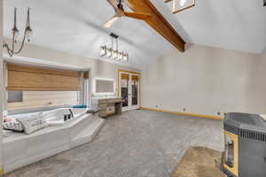 Full bathroom featuring a bath, carpet flooring, vanity, french doors, and a wood stove