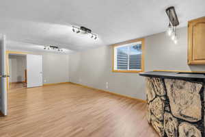 Unfurnished living room featuring a textured ceiling and light wood-style floors