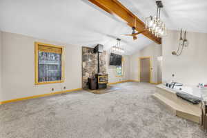 Unfurnished living room with a wood stove, carpet floors, and a ceiling fan
