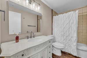Bathroom featuring dark wood finished floors, vanity, shower / bath combo, and a textured ceiling