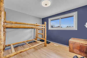 Bedroom with light wood-style flooring and a textured ceiling