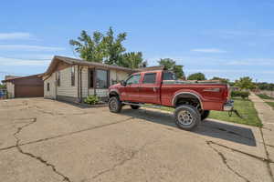 View of property exterior with a garage and roof with shingles