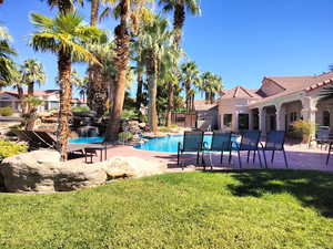 Community pool with a patio and a yard