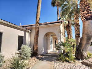 Entrance to property featuring stucco siding and a tile roof