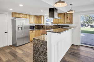Kitchen featuring stainless steel appliances, dark stone countertops, recessed lighting, light wood-type flooring, and pendant lighting