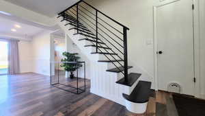 Staircase featuring hardwood / wood-style flooring