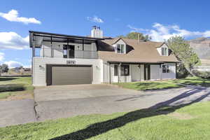 View of front of house featuring concrete driveway, a chimney, and a front lawn