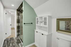 Full bath with dark wood-style flooring, a stall shower, a textured ceiling, and recessed lighting