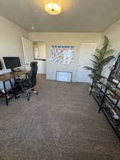 Office featuring a textured ceiling and carpet