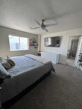 Bedroom featuring carpet, a textured ceiling, and ceiling fan