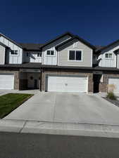 View of front of house with brick siding, driveway, and an attached garage