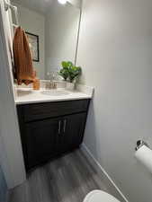 Half bathroom with vanity and dark wood finished floors