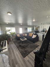 Living area featuring a textured ceiling and dark wood-style floors