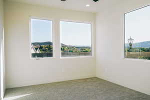 Carpeted empty room featuring plenty of natural light, a mountain view, recessed lighting, and ceiling fan