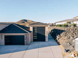View of front of property featuring stucco siding, a mountain view, concrete driveway, an attached garage, and a tiled roof