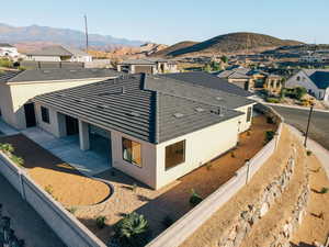 View of side of property featuring a fenced backyard, stucco siding, a patio area, a residential view, and a mountain view