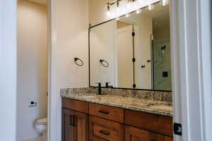 Full bath featuring double vanity and a shower stall