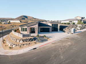 View of front of property with brick siding, driveway, a mountain view, and a garage