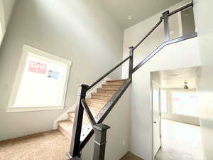 Stairs featuring a high ceiling and ceiling fan