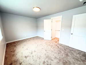 Unfurnished bedroom with carpet and baseboards