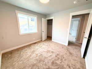 Unfurnished bedroom with a spacious closet and carpet