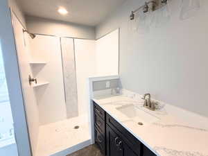 Bathroom featuring vanity and a stall shower