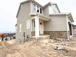 View of front of home with a porch and stone siding