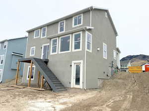 Back of property with stairs and stucco siding