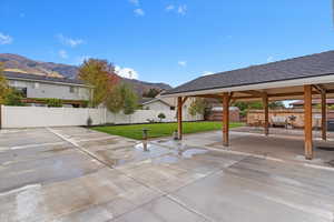 Fenced backyard with a mountain view and a patio area