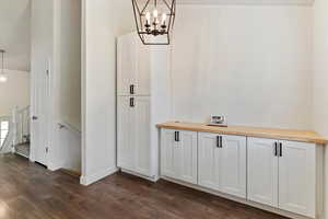 Interior space with a chandelier and dark wood-style flooring