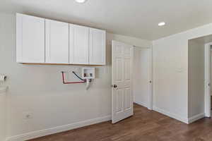 Washroom featuring recessed lighting, washer hookup, dark wood-style flooring, and cabinet space