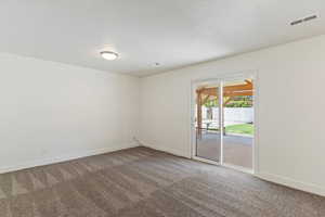 Carpeted spare room featuring baseboards and a textured ceiling
