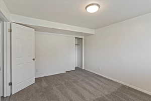 Unfurnished bedroom with a closet, carpet flooring, and a textured ceiling