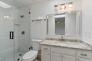 Full bathroom with a shower stall, vanity, and ceiling fan