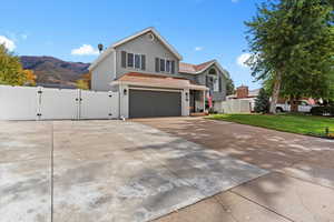 View of front of home featuring a gate, driveway, an attached garage, and brick siding