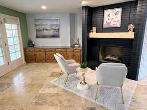 Sitting room with a brick fireplace and recessed lighting