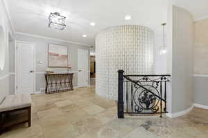 Hall with an upstairs landing, crown molding, and recessed lighting