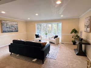 Living room featuring recessed lighting, ornamental molding, and carpet flooring