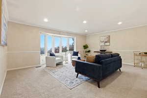 Living room featuring light colored carpet, crown molding, and recessed lighting