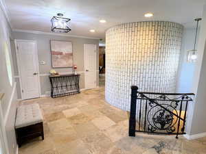 Corridor featuring recessed lighting, crown molding, an upstairs landing, light stone finish floors, and a chandelier