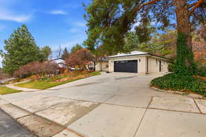 View of property exterior with concrete driveway, brick siding, and a garage