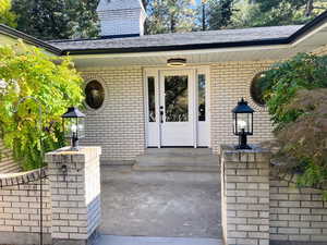 Doorway to property with brick siding and a porch